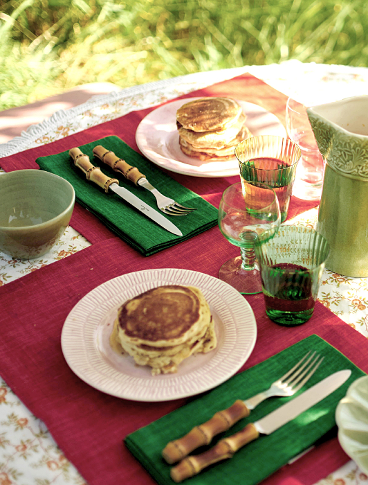 新緑の庭でマテュースのピンクの皿と緑のグラス、バンブーのカトラリーを並べた、春のパンケーキランチのテーブルコーディネート