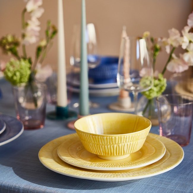 黄色いボウルとプレートを重ねた春のイースターのテーブルコーディネート。おもてなしの食卓風景